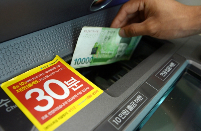 한 은행 ATM에서 시민이 돈을 인출하고 있다. 뉴시스