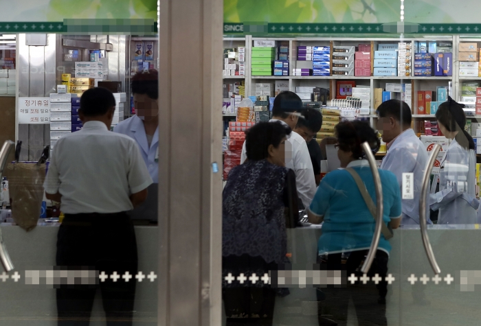 식약처가 발사르탄 제제 고혈압약 발암물질 리스트를 공개한 이후 서울의 한 약국에서 환자들이 새로운 약품을 구입하고 있다. 뉴시스