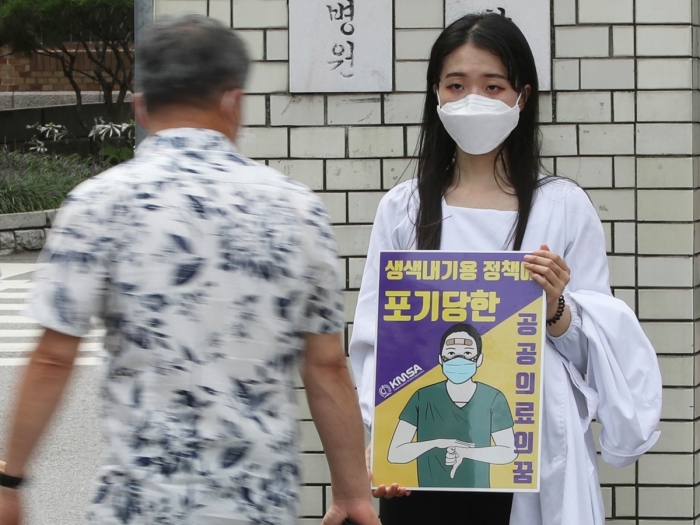 지난 8월 서울대학교 연건캠퍼스 의과대학 앞에서 본과 3학년생이 1인시위를 하고 있는 모습. 덕분에 챌린지를 패러디한 '덕분이라며 챌린지'서 사용한 이미지를 들고 있다.