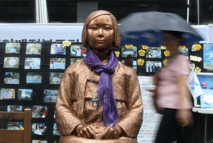 서울 종로구 구 일본대사관 앞 평화의 소녀상 옆을 한 시민이 우산을 쓰고 걸어가고 있다. 
