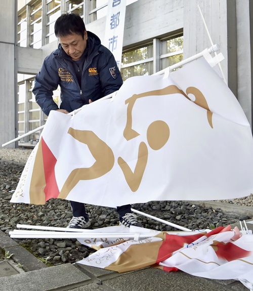 도쿄올림픽이 1년 연기되면서 올림픽 성화도 1년을 기다린 뒤 경기장에 도착한다. 지난해 3월 25일 일본 아이치현 이나자와 시청에서 한 작업자가 성화봉송 관련 현수막을 철거하던 모습. AP/뉴시스