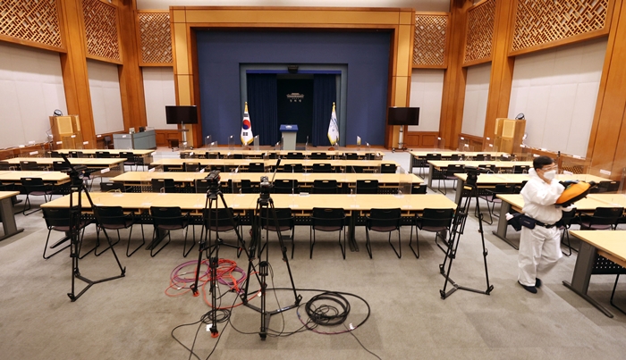 지난 7월 11일 코로나19 재확산으로 폐쇄된 청와대 춘추관 기자실에서 관계자가 방역작업을 하는 모습. 뉴시스