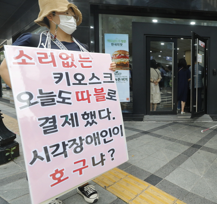 키오스크는 '유리장벽' 2022년 7월 11일, 시각장애인권리보장연대가 서울 중구의 한 햄버거점에서 '키오스크 내돈내산 권리찾기 캠페인'을 하고 있다. 이들은 키오스크 등 시각장애인의 정보 접근 차별 철폐를 주장했다. 뉴시스